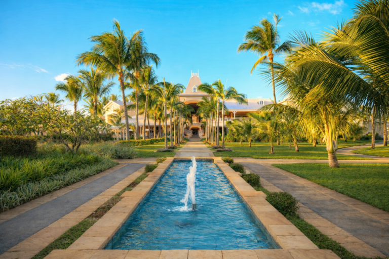 Luxury resort in Mauritius at sunset with palm trees and pool